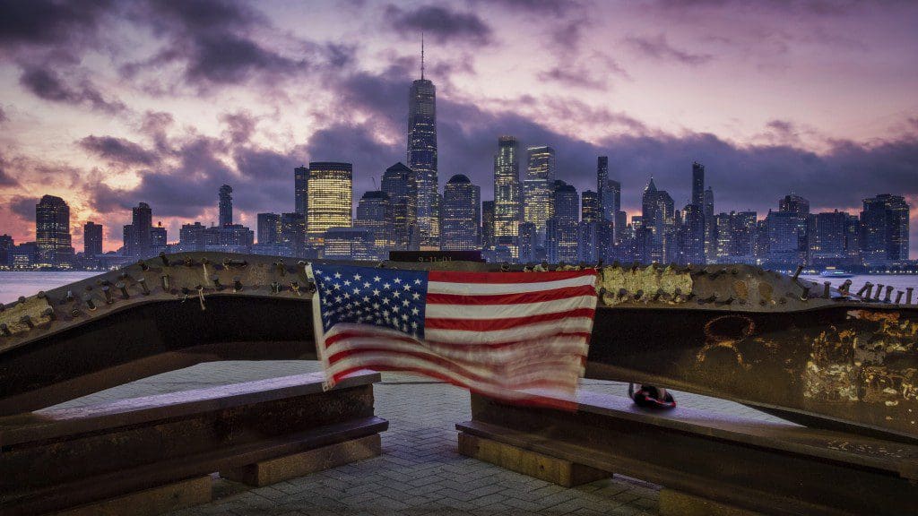 A picture of the American flag in front of the New York City skyline