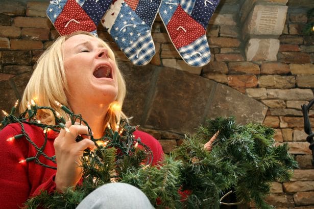 Women crying with Christmas lights and garland in hand